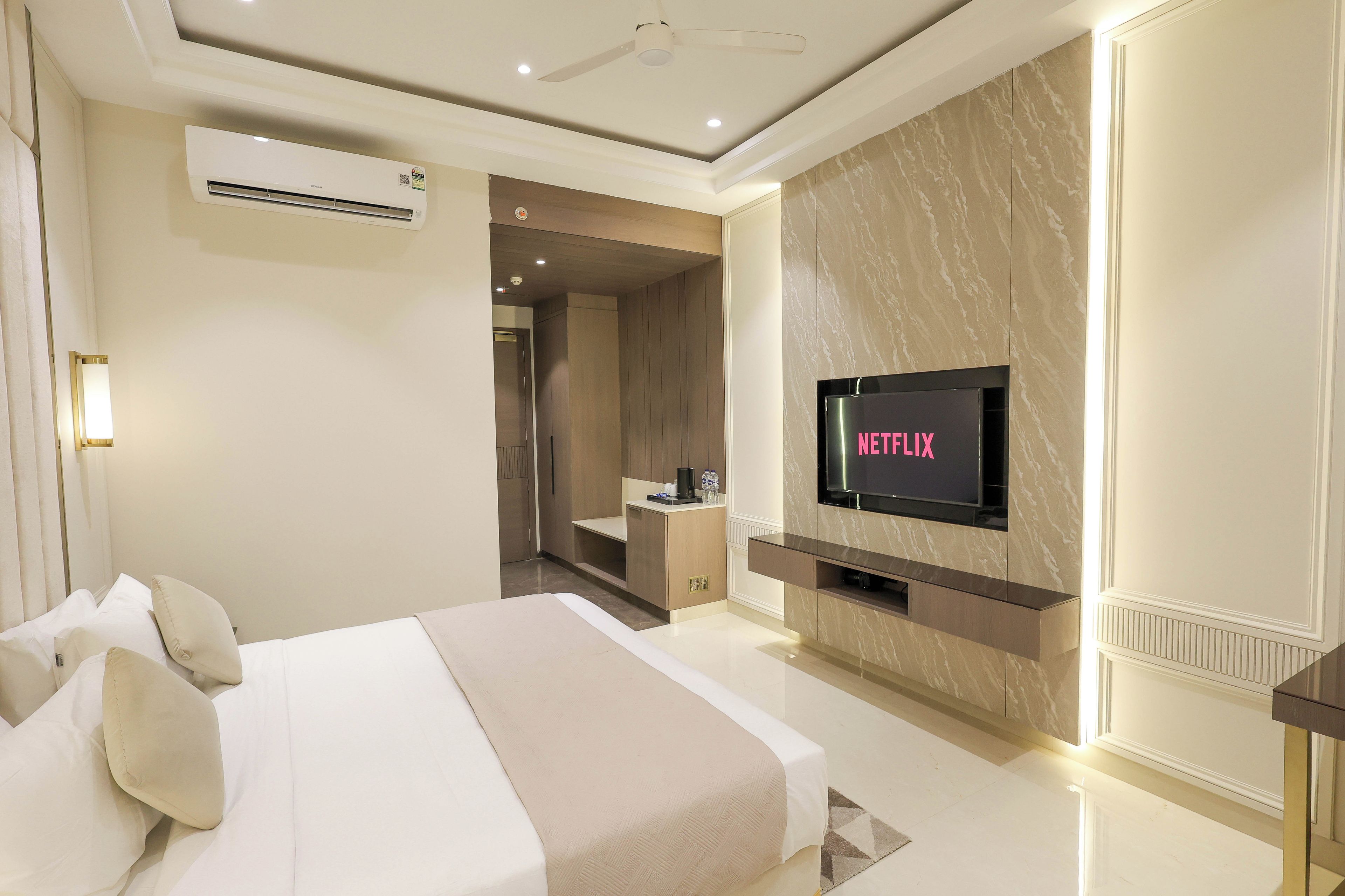 Ein modernes Hotelzimmer mit Bett, Wandfernseher und Klimaanlage.