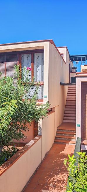 A narrow pathway leading to a building with a tiled roof and a staircase. - Casa Tanca Manna (Tanca Manna)