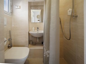 Un bany amb vàter, rentamig i plat de dutxa.