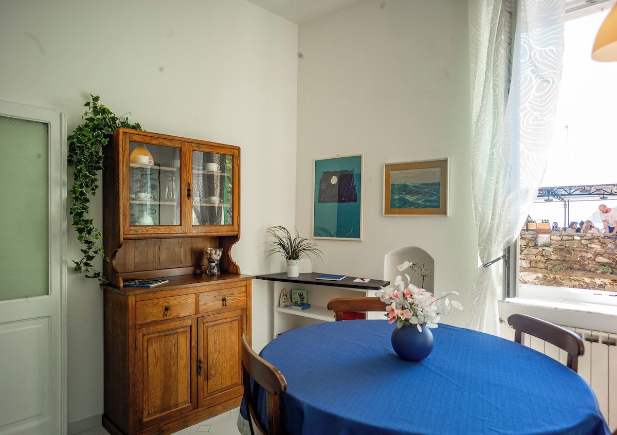 Un comedor con una mesa redonda, un aparador de madera y una ventana con vistas.