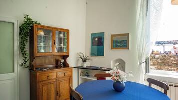 Un comedor con una mesa redonda, un aparador de madera y una ventana con vistas.