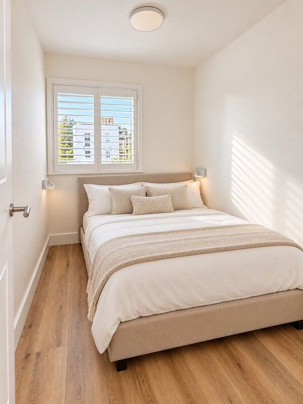 Un dormitorio con una cama, una ventana y una puerta.