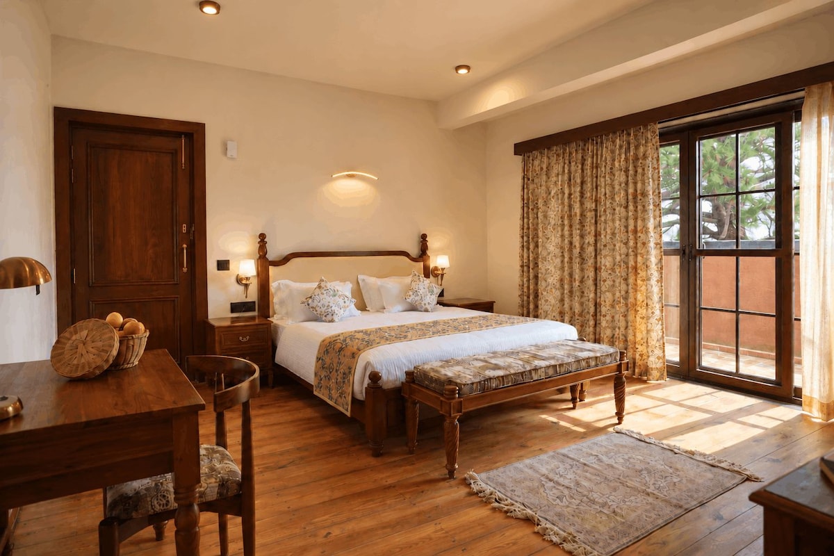 A bedroom with a wooden bed, a nightstand, a desk, and a chair.