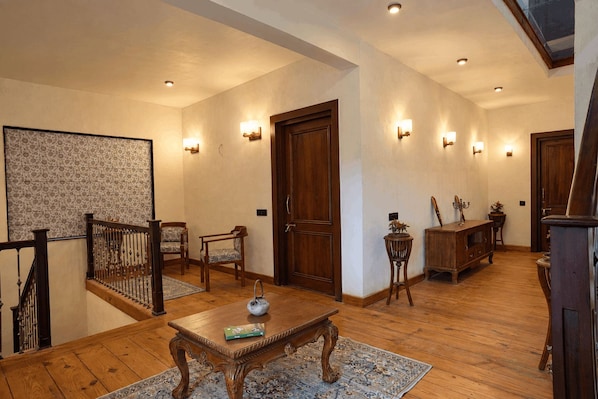 Un pasillo amplio con piso de madera, una escalera y un comedor con mesa y sillas.