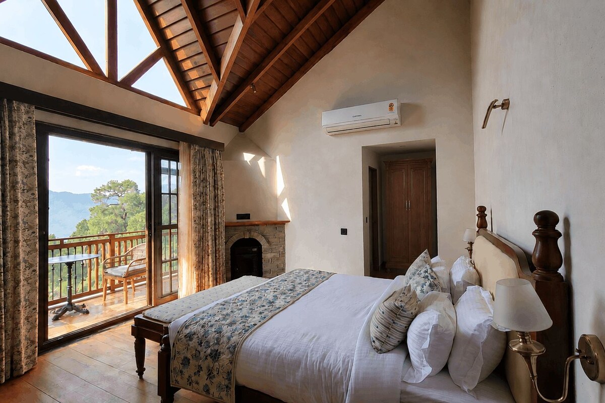 A bedroom with a large bed, a wooden headboard, a nightstand, a lamp, and a view of the outdoors through a sliding glass door.