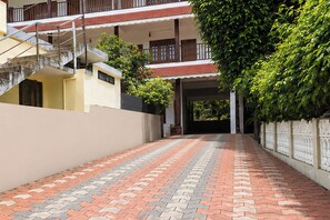 A corridor with a patterned floor leading to a building entrance. - Collection O Elephant Camp Thekkady (Thekkady)