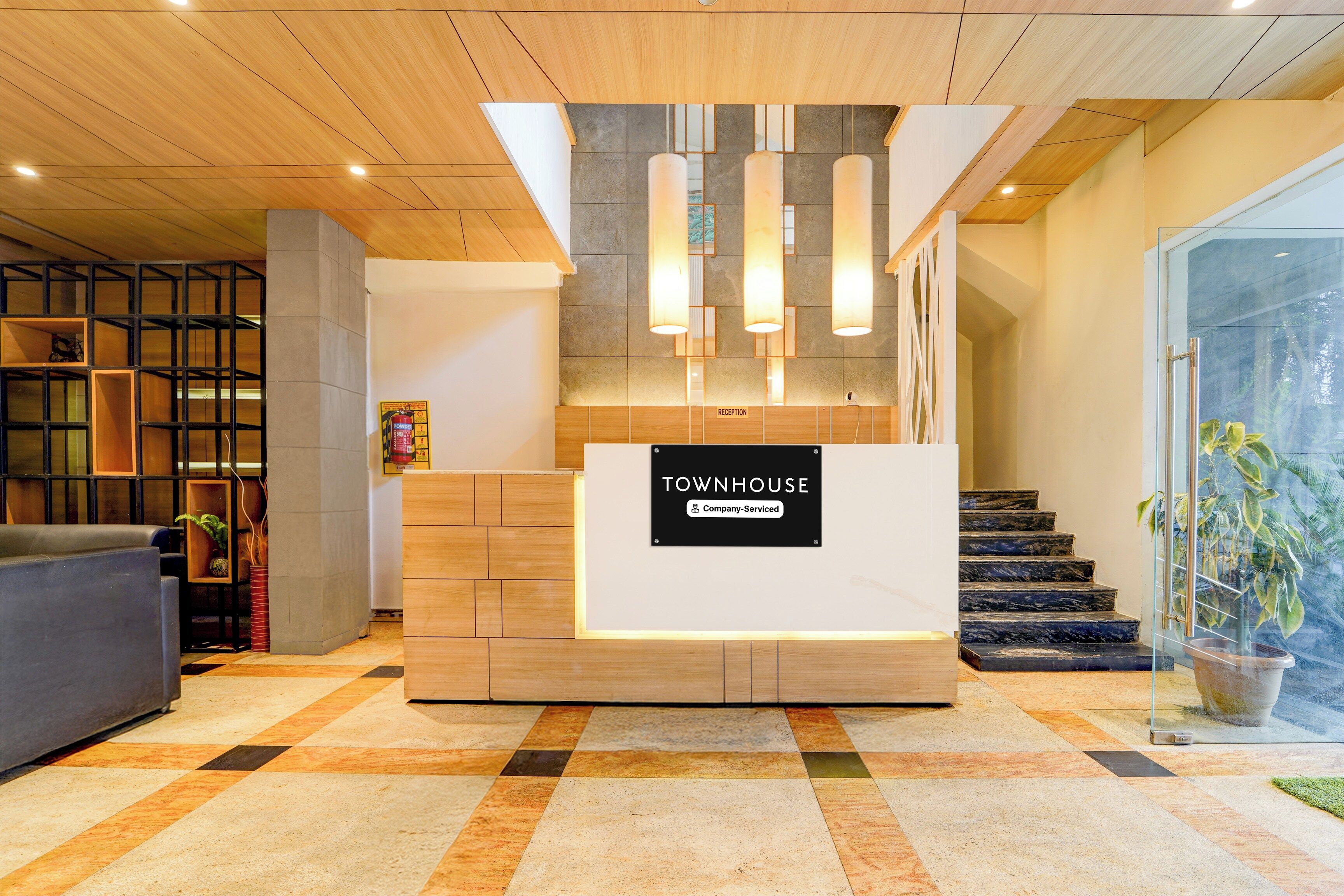 A reception desk with a sign indicating it's a company-serviced townhouse.