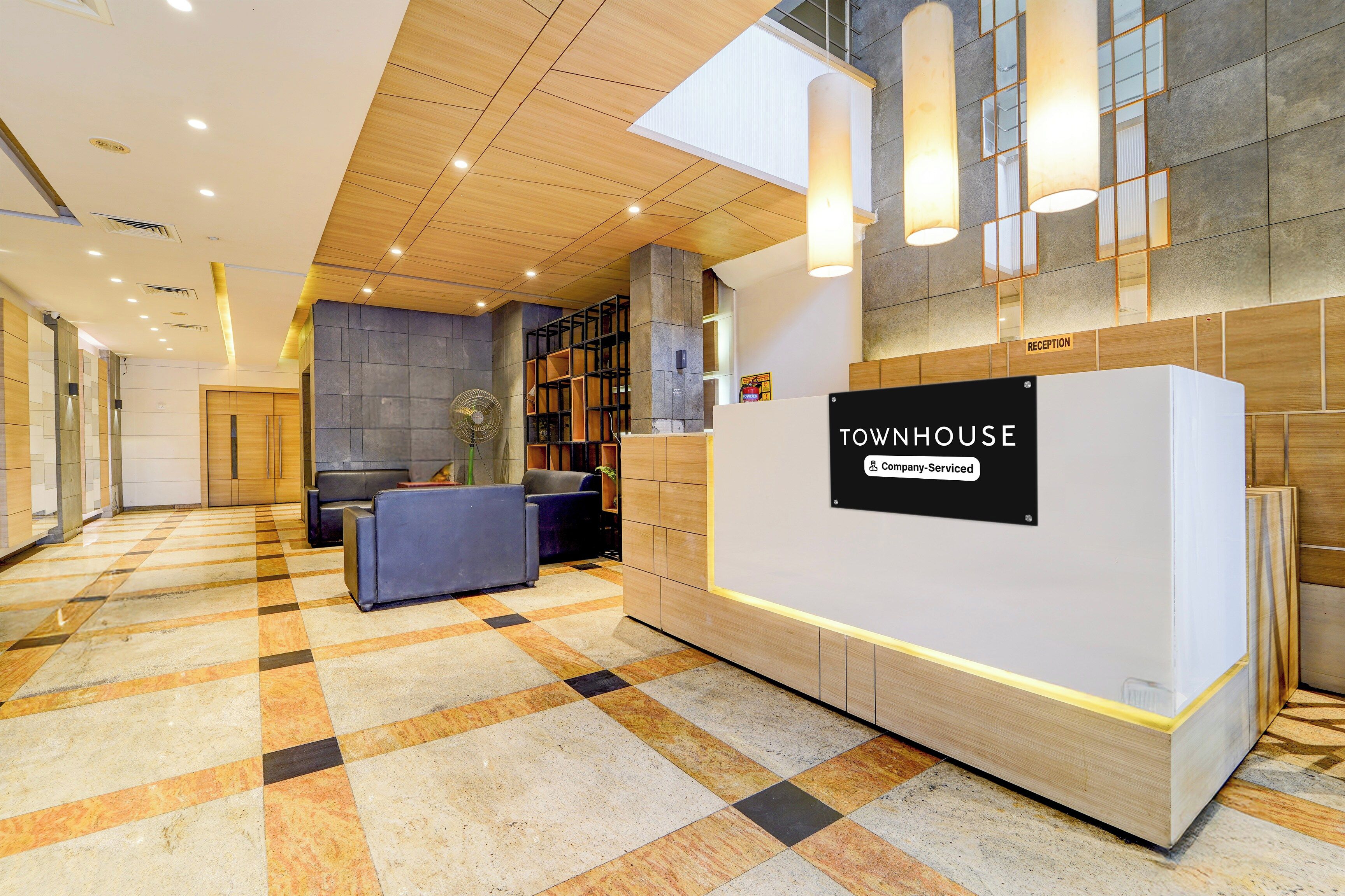 A reception area with a check-in counter, seating, and a reception desk.