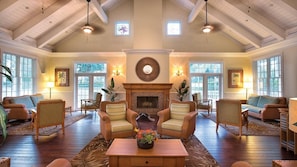 A spacious living room with a fireplace, multiple seating areas, and large windows. - 3BR Suite at WorldMark Kingstown Reef Near Disney & Universal Orlando (Orlando)