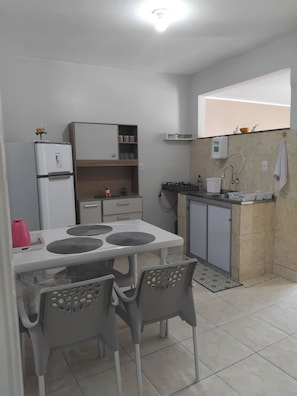 Eine kleine Küche mit Kühlschrank, Spüle und Arbeitsfläche.