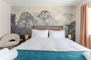 A neatly made bed with white linens, a headboard, and a teal throw blanket. - Crawley 1BR | Modern Apartment F2 | Three Bridges (London)