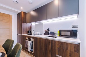 Een moderne keuken met inbouwapparatuur, een magnetron en een koffiezetapparaat.