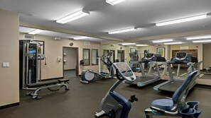 A gym with various exercise equipment, including treadmills, elliptical machines, and weight machines.