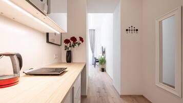Eine moderne Küche mit Arbeitsplatte, einem Wasserkocher und einer Vase mit Blumen.