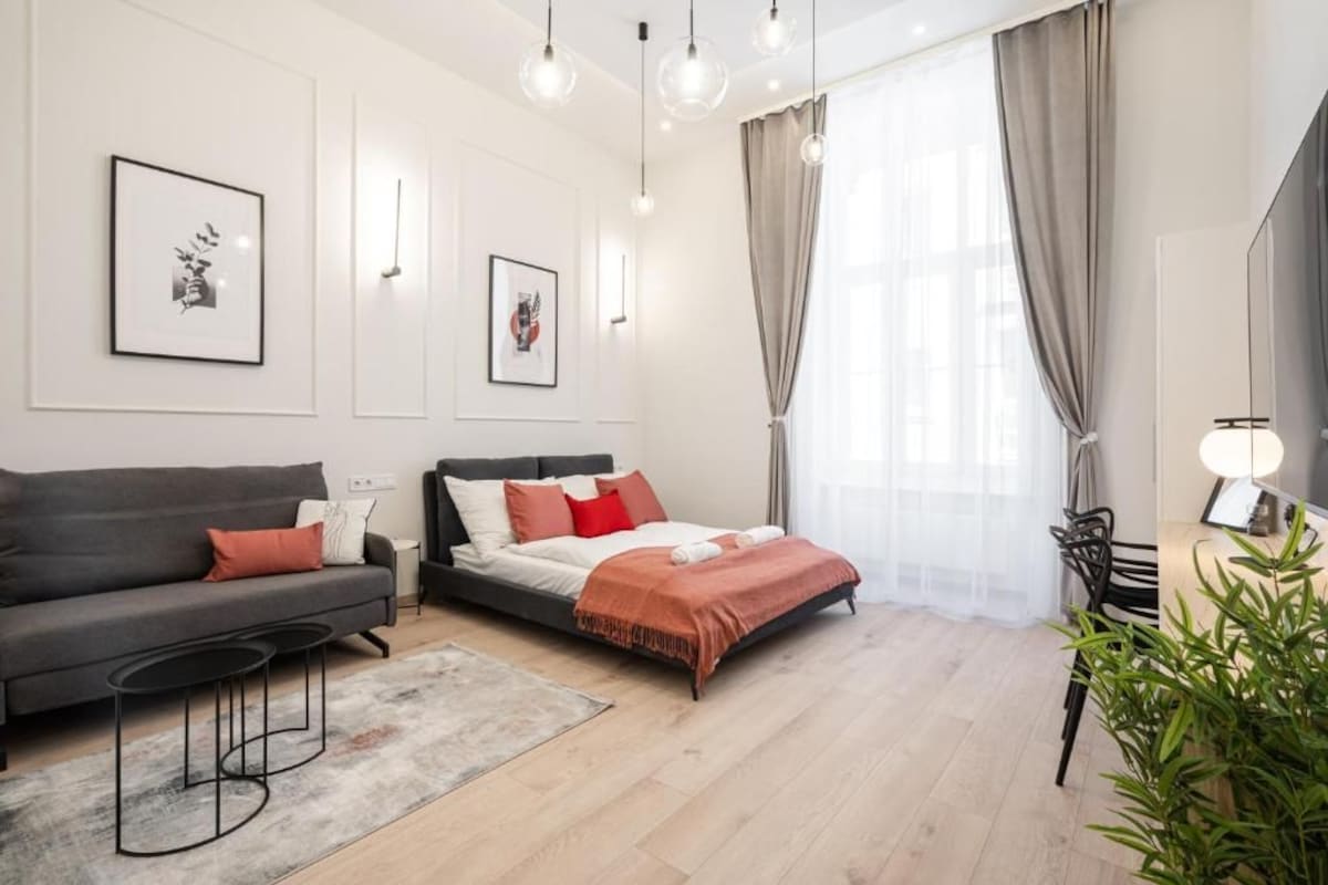 Ein modernes Schlafzimmer mit Bett, Sofa, Schreibtisch und Stuhl.