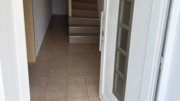 Ein Flur mit einer Tür zu einer Treppe.