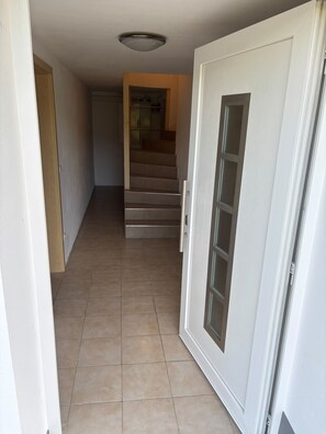 Un passadís amb una porta que dona a una escala.