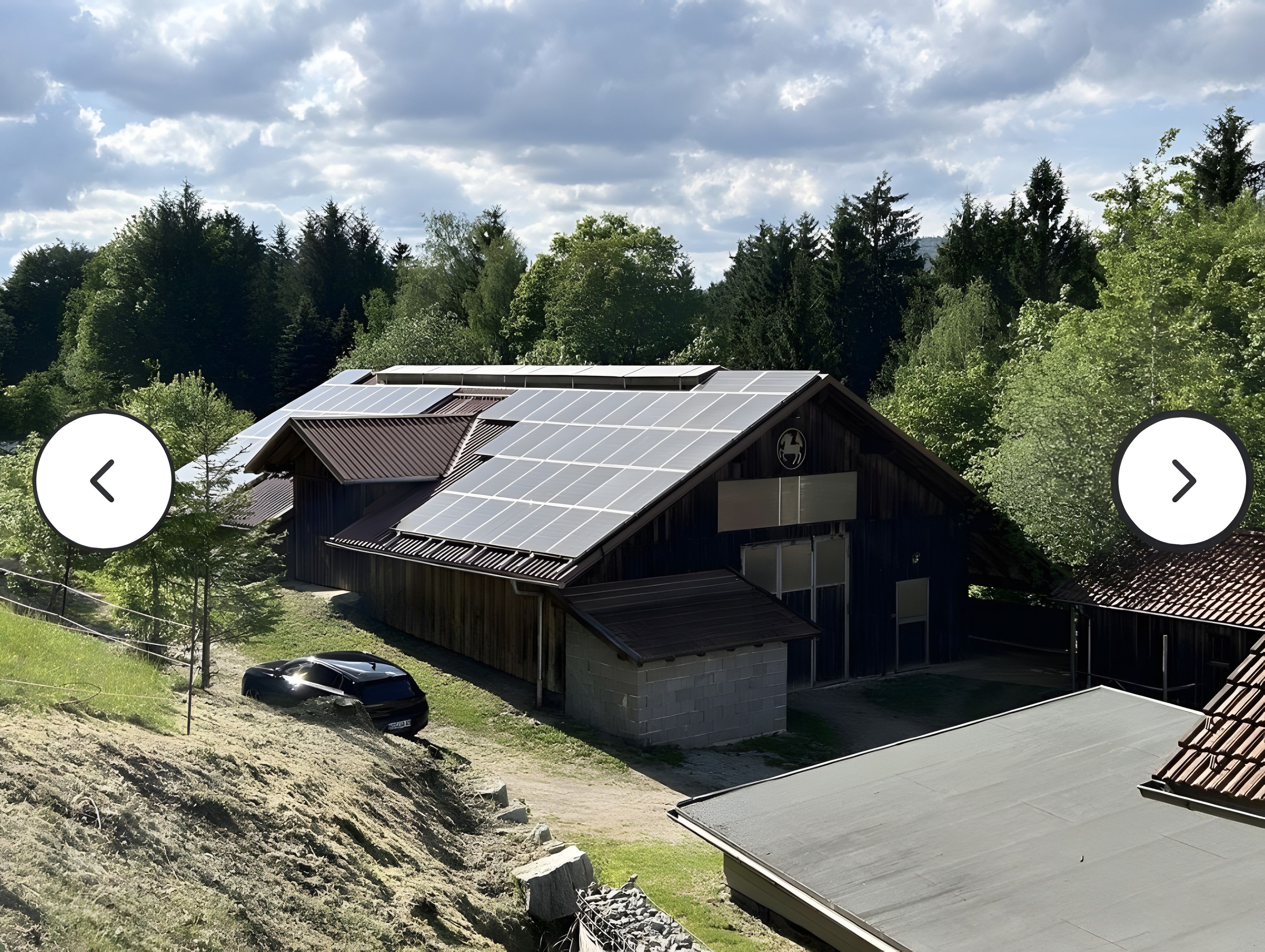 Un bâtiment doté d’un toit en pente, de panneaux solaires et d’un garage.