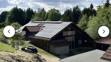 A building with a sloped roof, solar panels, and a garage.