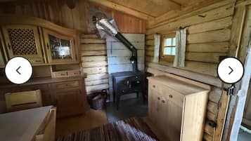 Ein rustikales Holzhaus-Interieur mit Kamin, Holzschränken und einem Fenster mit Vorhängen.