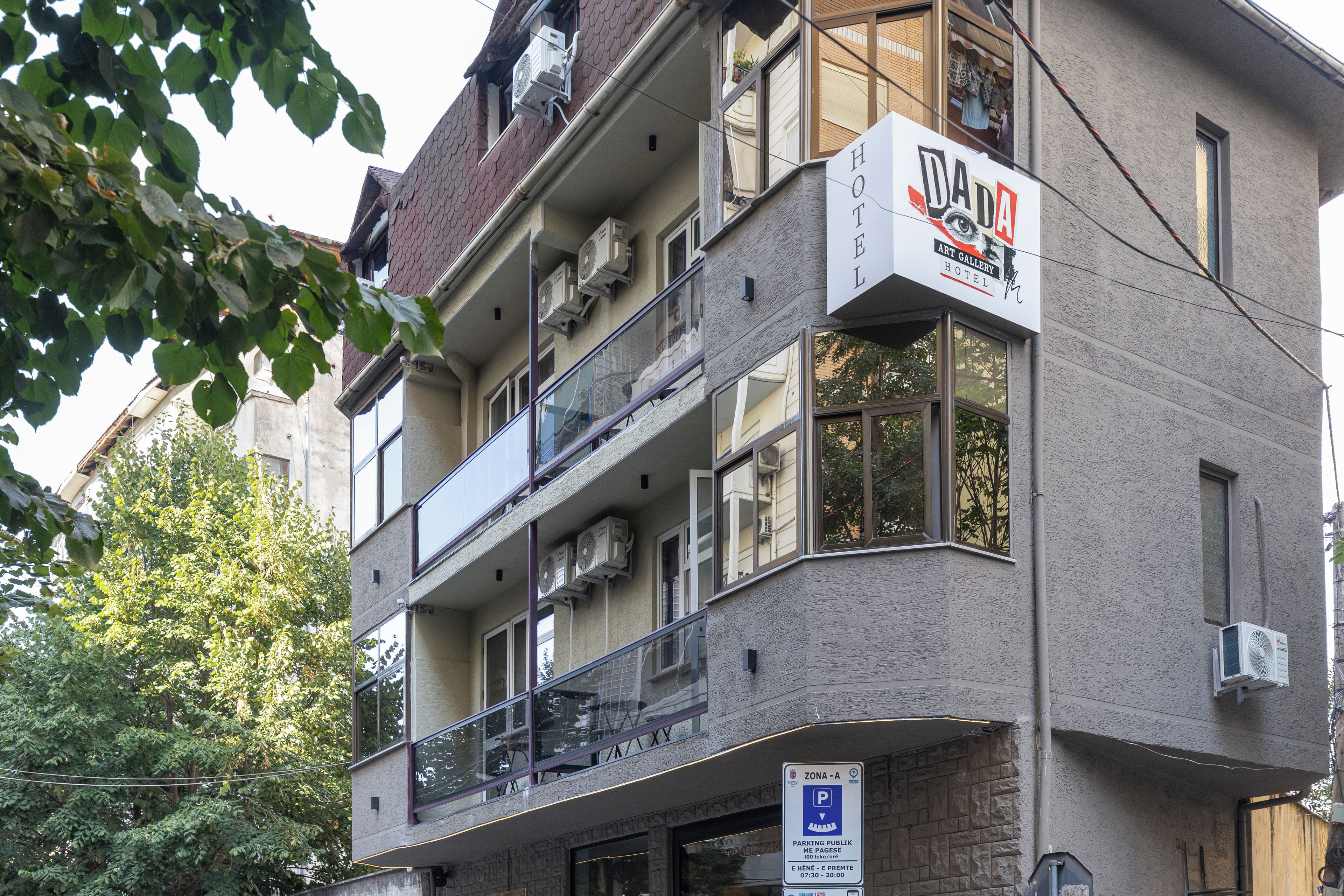 Un edificio de varios pisos con un cartel que indica que es un hotel y una galería de arte.