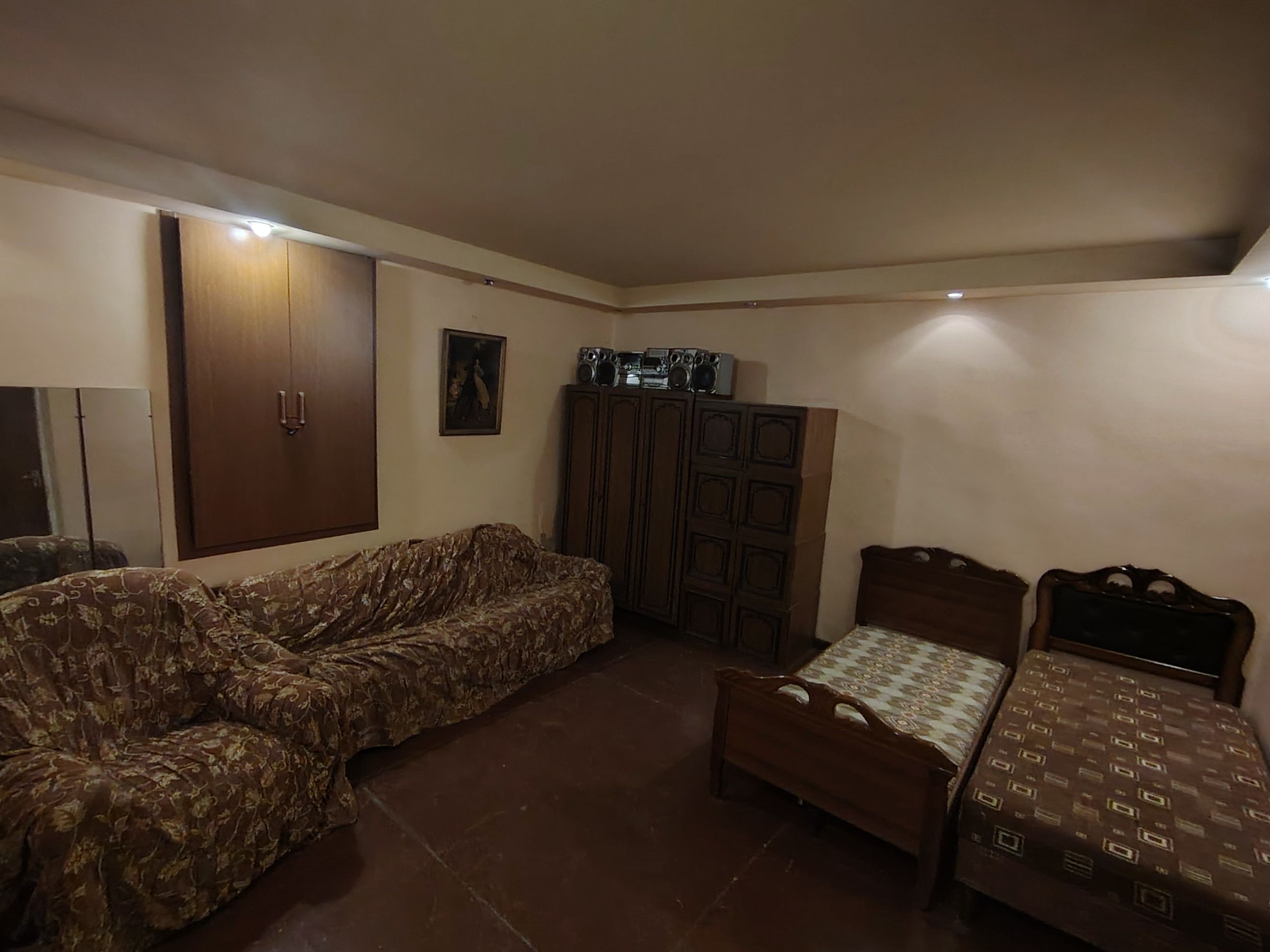 Une pièce comprenant un canapé, un lit, une armoire et un téléviseur.