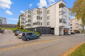 A modern multi-story residential building with a parking area in front. - Arctic Riverside Retreat – Private Sauna - Central (Rovaniemi)