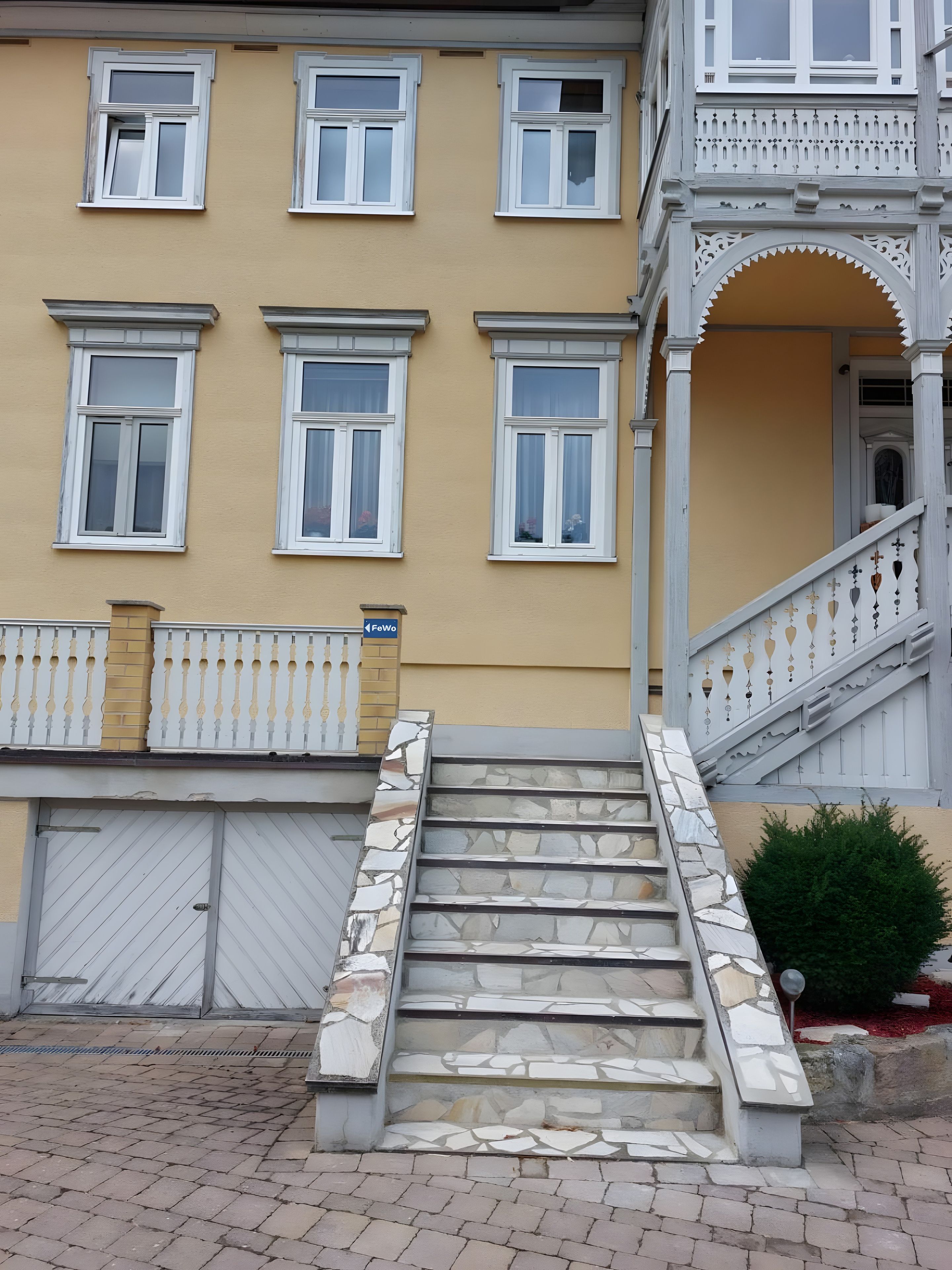 Ein Gebäude mit vielen Fenstern, einer Steintreppe und einem ehrfurchtgebietenden Eingangstor.