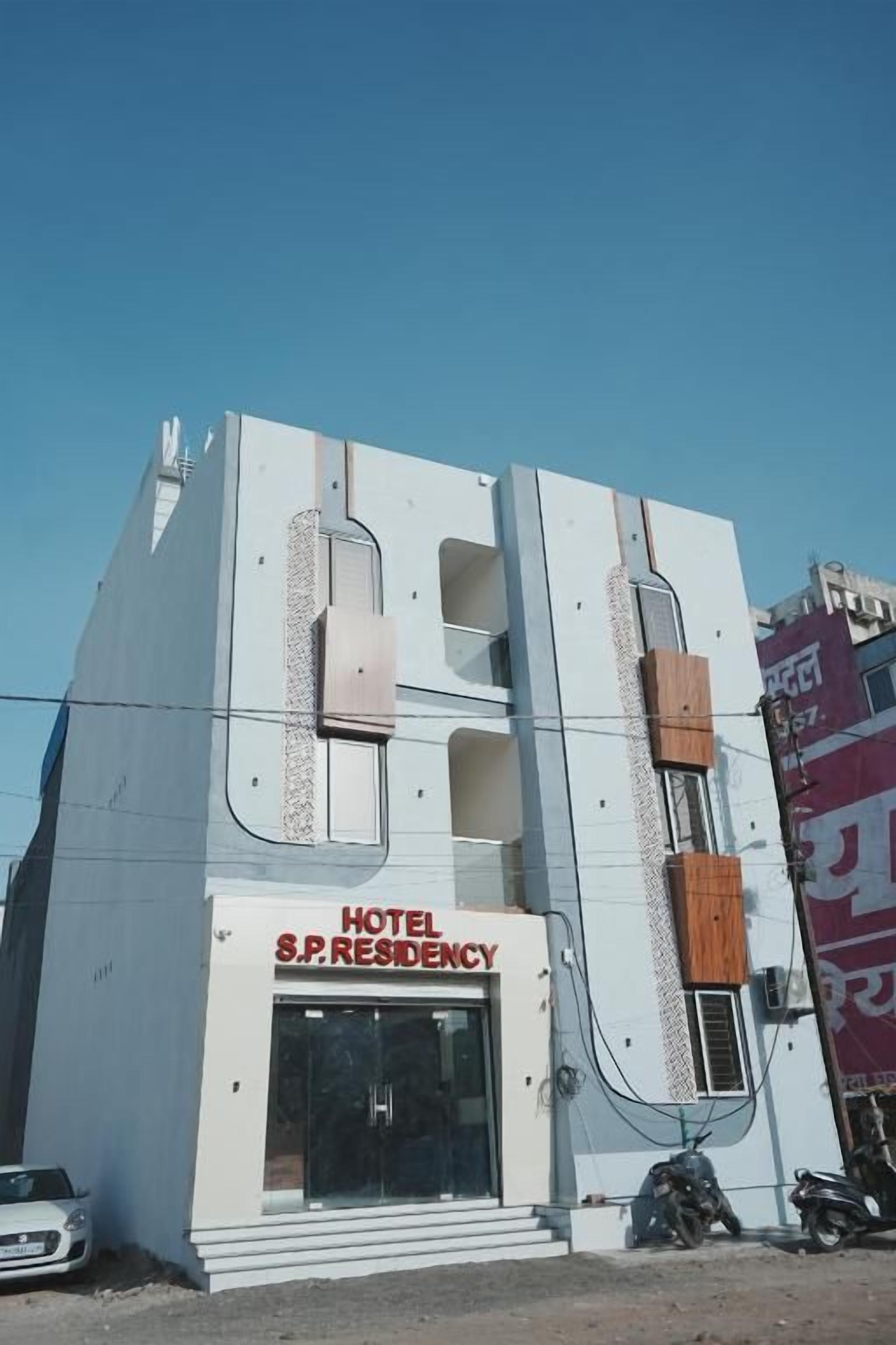 Um hotel com uma placa indicando 'HOTEL S.P. RESIDENCY' e uma entrada visível.