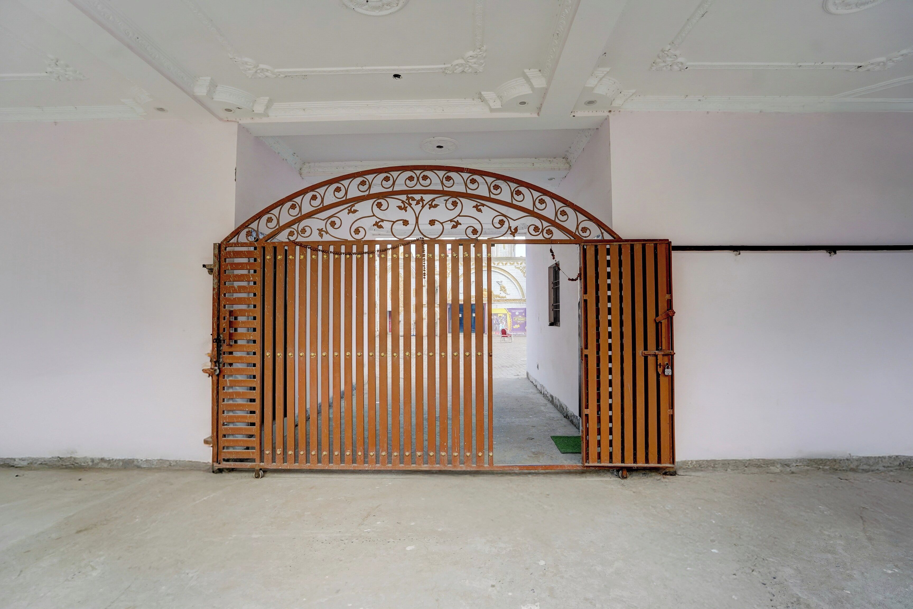 A gated entrance with a decorative metal arch and vertical bars.