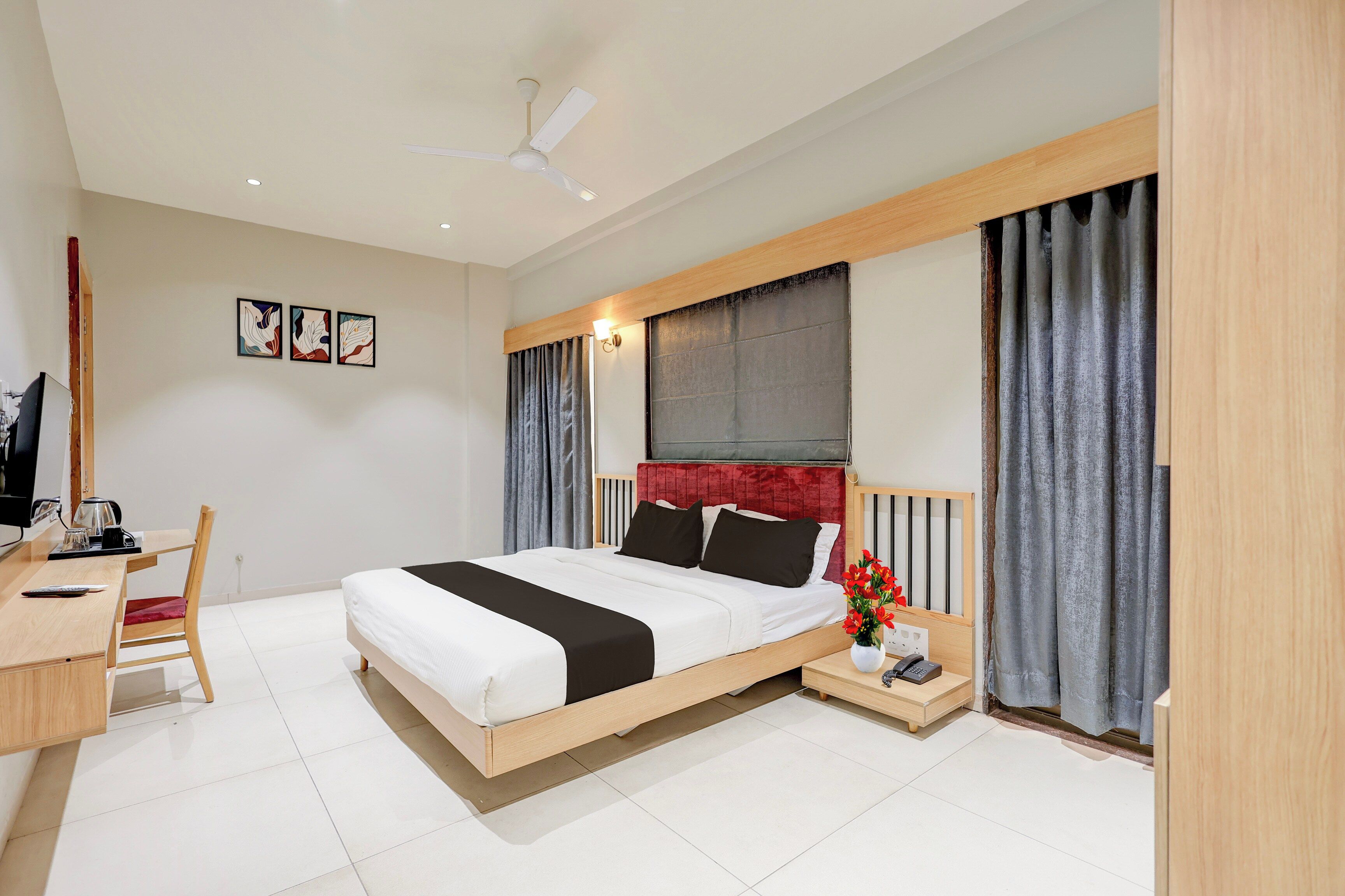 Una habitación de hotel moderna con cama, escritorio, silla y ventilador de techo.