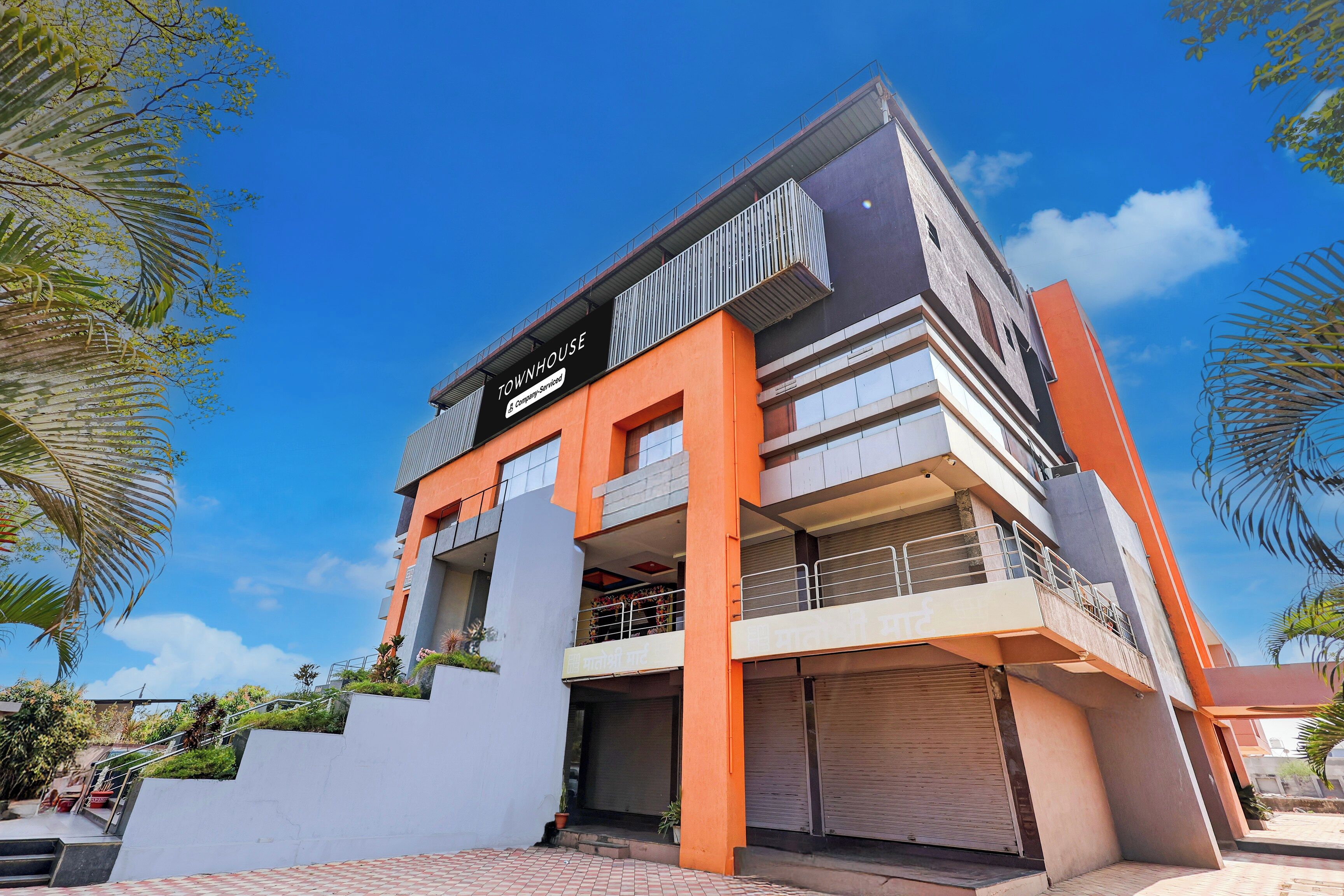 A multi-story building with a sign reading 'TOWNHOUSE' and balconies.