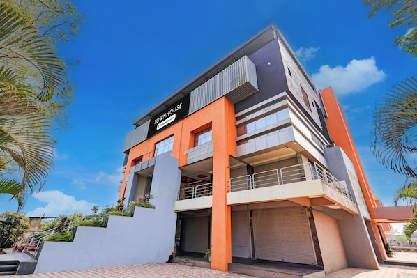 A multi-story building with a sign reading 'TOWNHOUSE' and balconies.