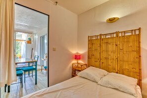Une chambre d’hôtel avec un lit, une table et des chaises, une lampe et une vue sur l’extérieur.