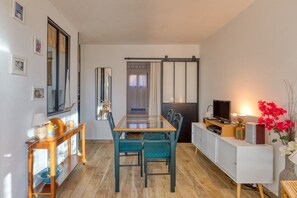 A compact living space with a dining area, a seating area with a TV, and a kitchenette. - By the Water...!!! 50 Meters from the Beach (Narbonne-Plage)