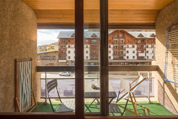 A balcony with a view of a street and buildings, including a casino. - Serre-Chevalier Vallée Briançon (Briançon)