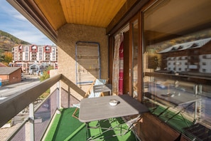 A balcony with a table and chairs, a drying rack, and a view of buildings in the background. - Serre-Chevalier Vallée Briançon (Briançon)