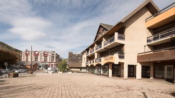 A paved square with buildings, balconies, and storefronts.