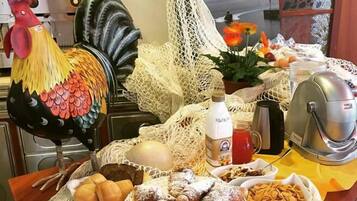 Ein reichhaltiges Frühstücksbuffet mit verschiedenen Backwaren, einer Dekoration mit einem Hahn und einem schönen Ausblick durch ein Fenster.