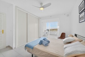 A bedroom with a bed, a ceiling fan, a view of the outdoors, and a sliding door. - Island Village Paradise apartment (Costa Adeje)