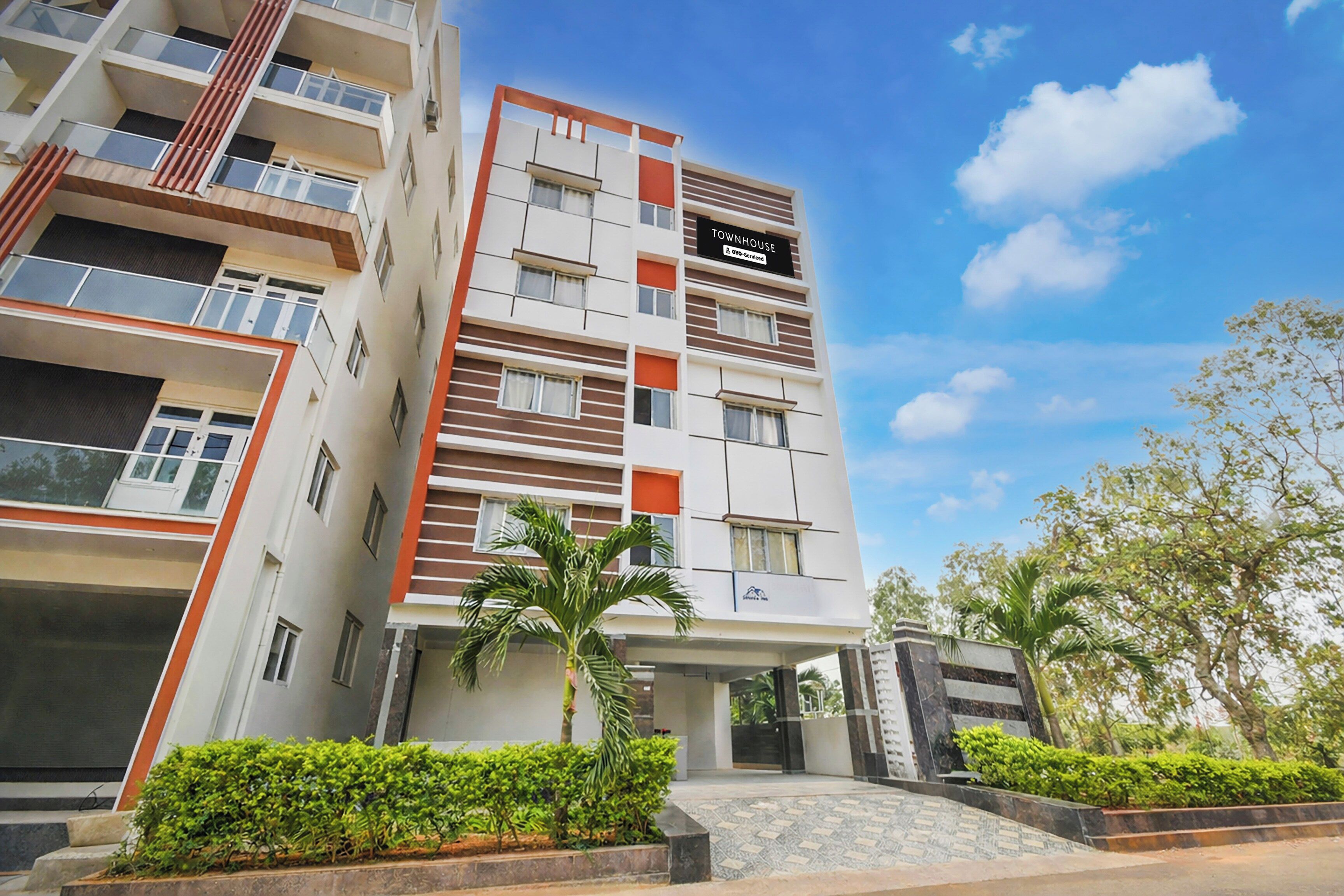 Un edificio residencial de varios pisos con balcones, una señal que indica que es un adosado y una entrada con acceso restringido.