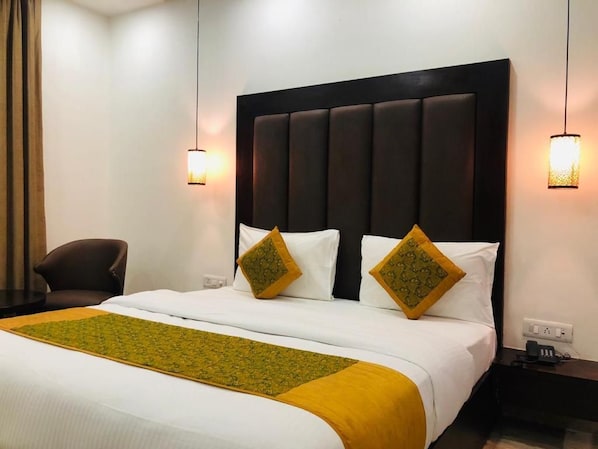 A hotel room with a large bed, two bedside lamps, a chair, and a nightstand.
