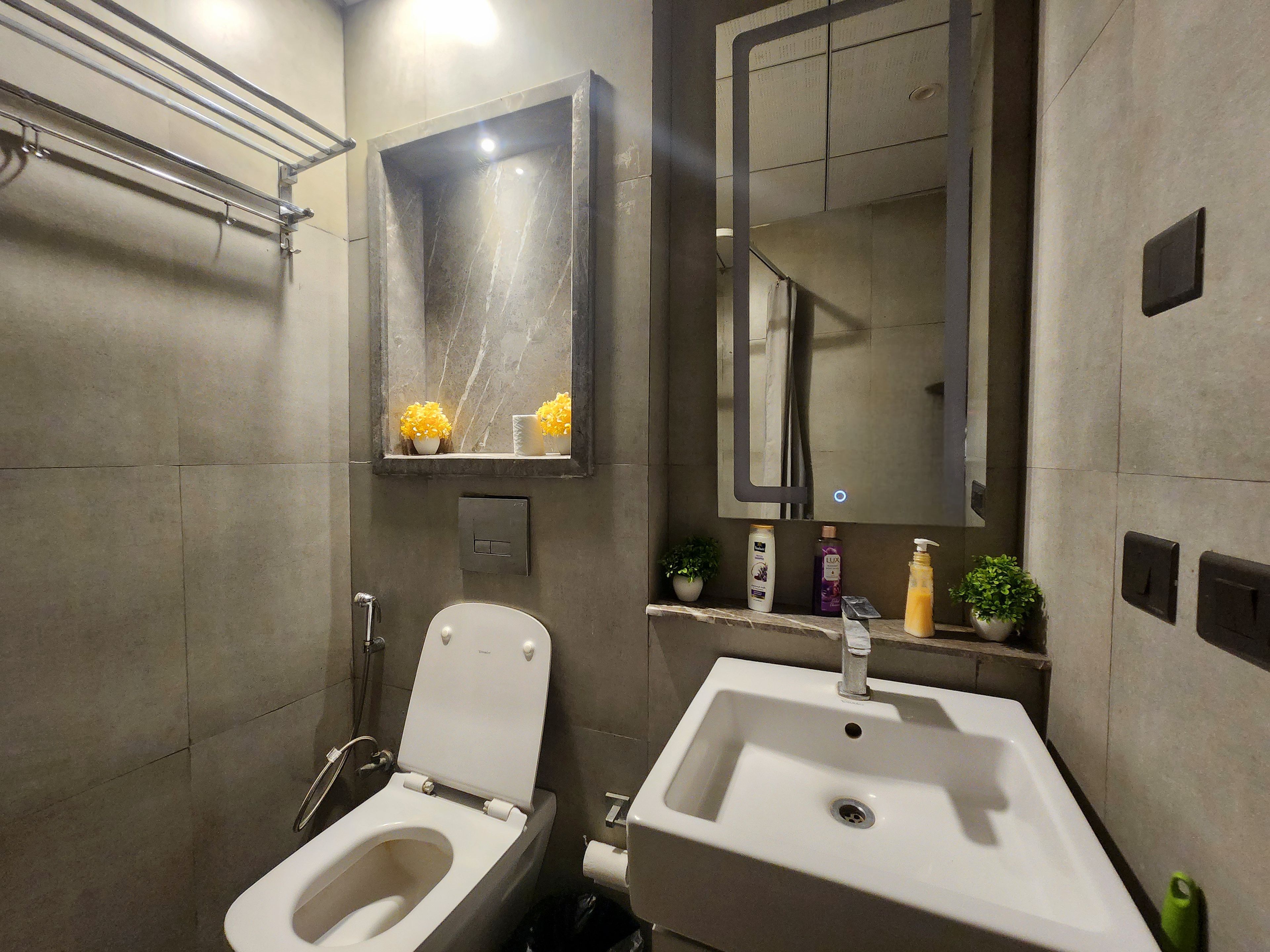 Un baño moderno con inodoro, lavabo y espejos.