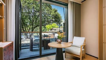 A modern room with a balcony, a round table, a chair, and a potted plant.