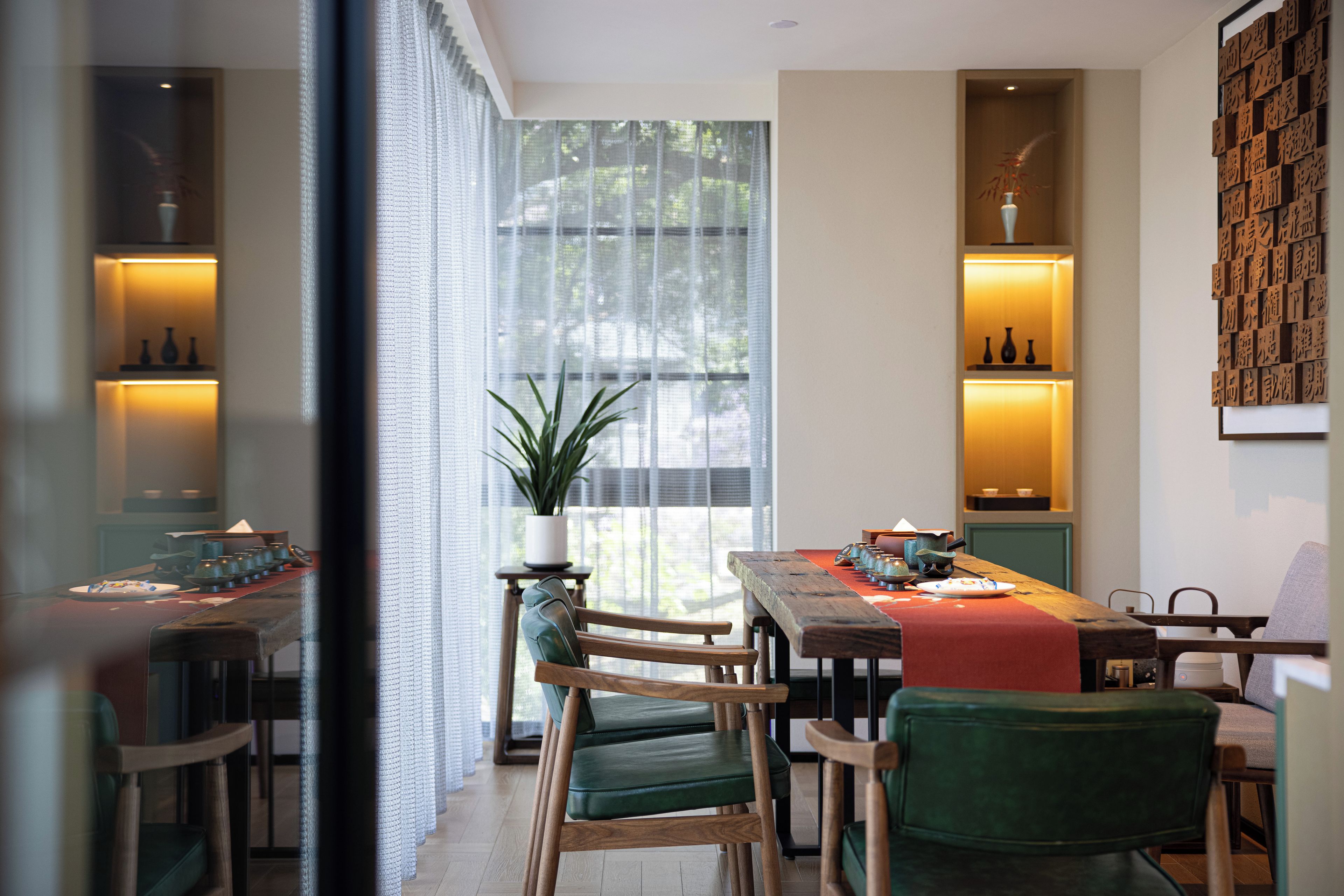 Un área de comedor con mesa de madera, sillas y una planta en maceta.