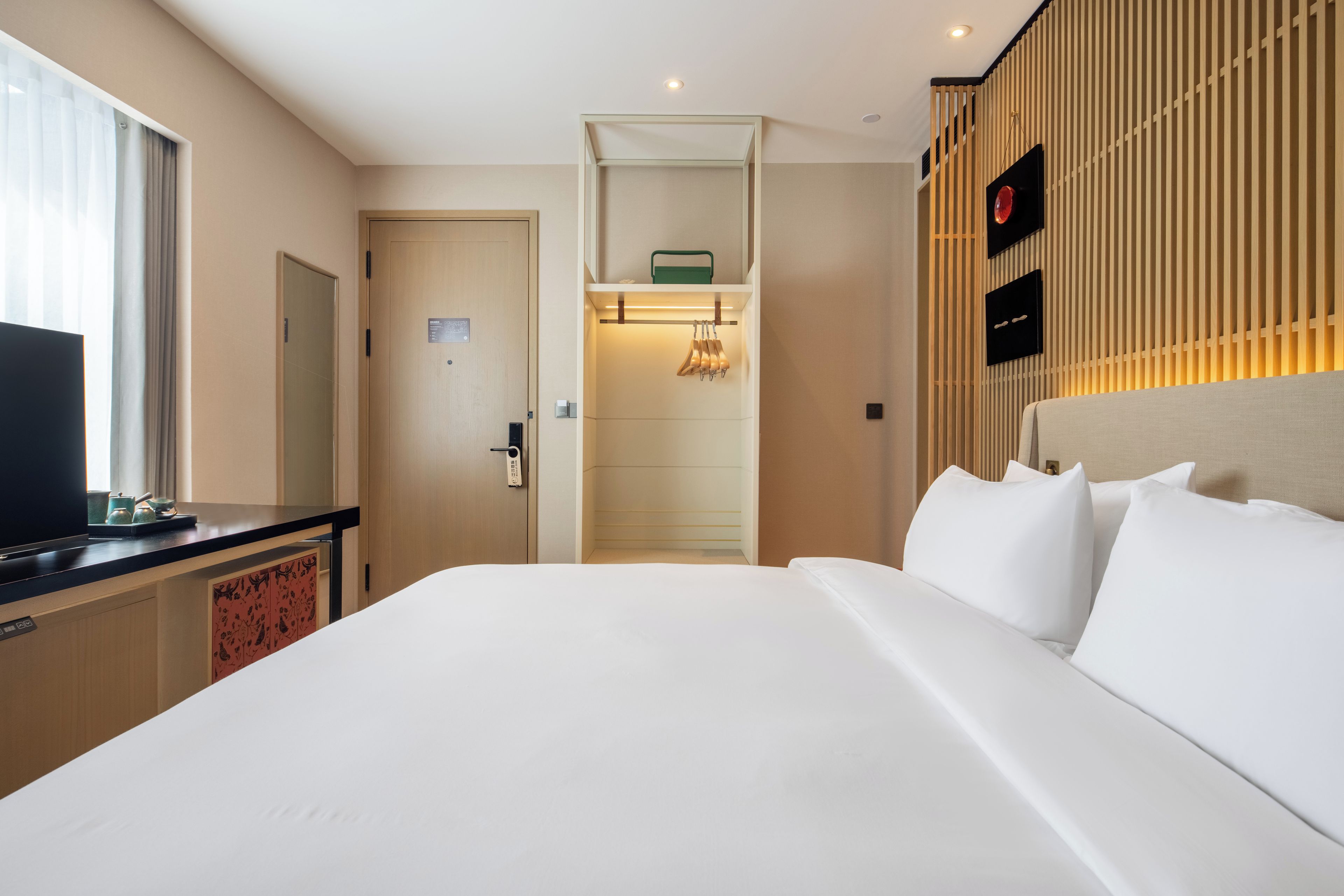 Ein Hotelzimmer mit einem Bett, einem Fernseher, einem Kleiderschrank und einem Badezimmer.