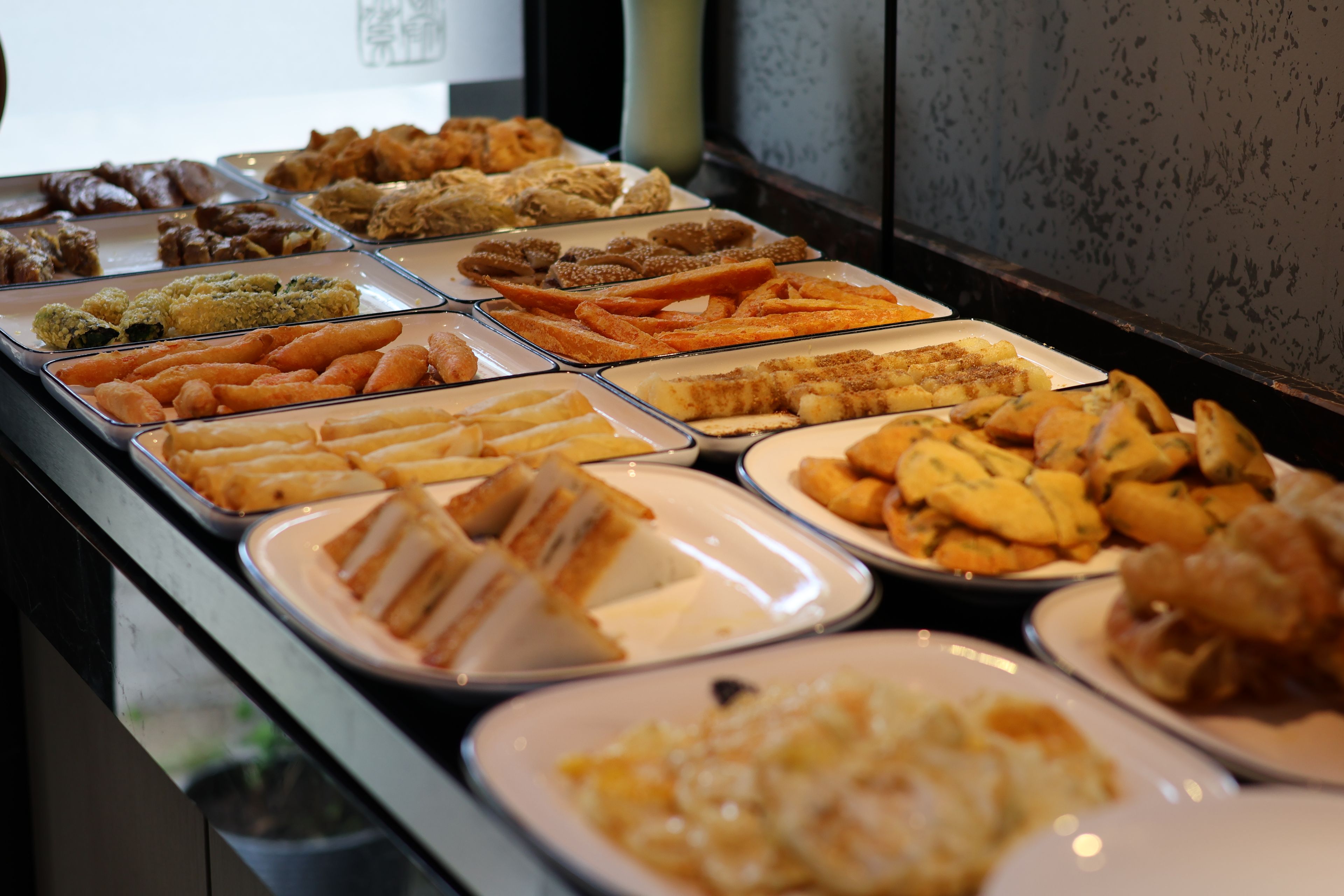 Buffet amb diferents plats, incloent pa, pastissos i altres aperitius.