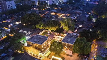 Vista aérea de un pueblo histórico con edificios tradicionales, un patio central y estructuras modernas circundantes.