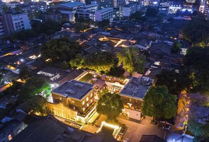 Vista aérea de un pueblo histórico con edificios tradicionales, un patio central y estructuras modernas circundantes.