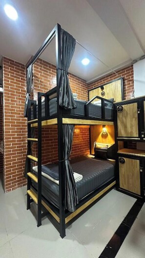 Una cama individual superpuesta con escalera, una mesita de noche y una lámpara.